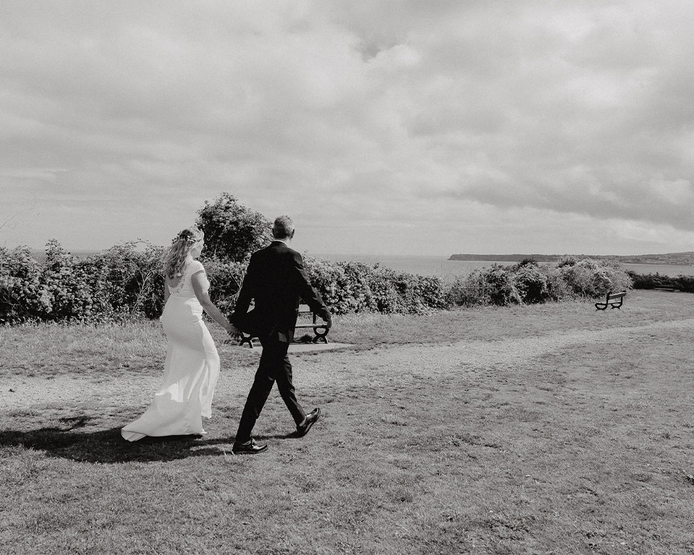 Bride and Groom walking along Daddyhole Plain in Torquay.