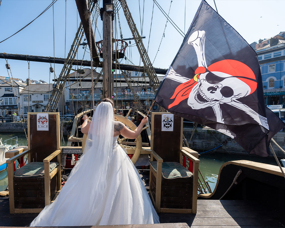 Bride waving Pirate flag on boat in Brixham.